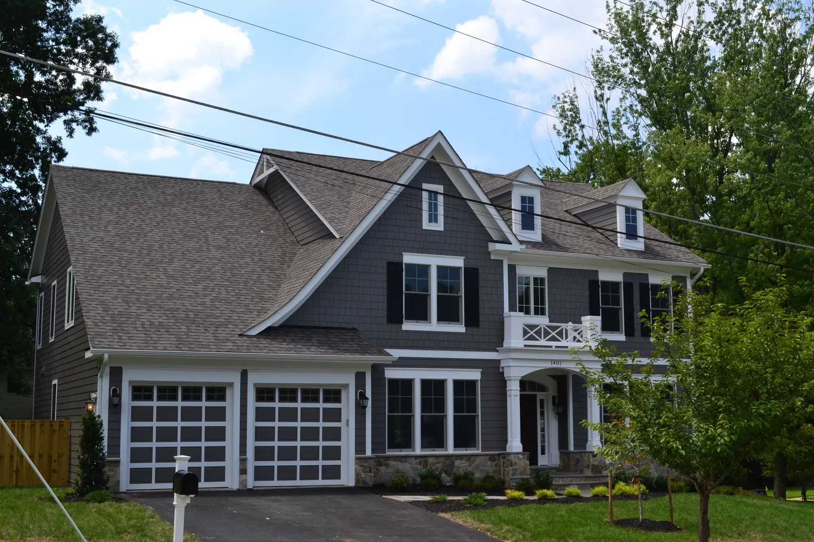 A large house with two garage doors and a driveway.
