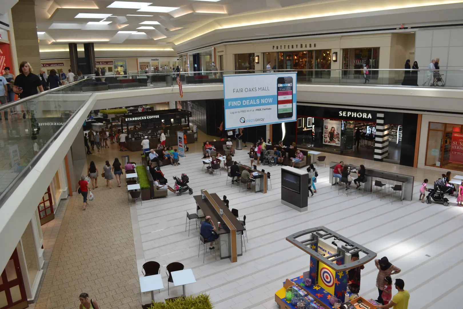 A mall with people sitting and walking around.