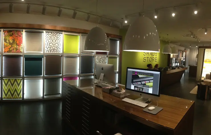 A computer desk with two lights hanging above it.